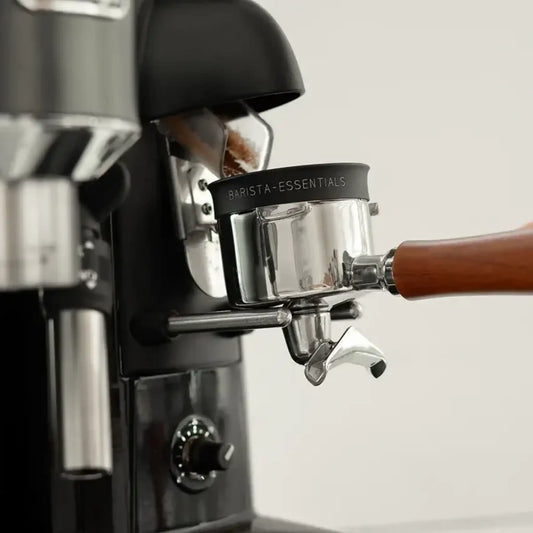 Zwarte doseerring op portafilter tijdens het malen om koffiemaling binnen het filterbakje te houden