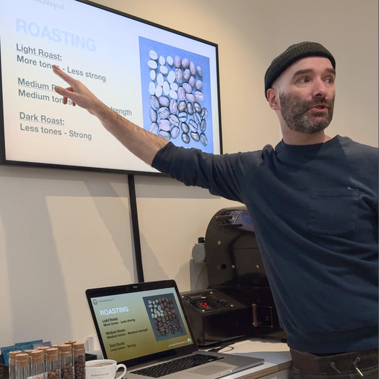 Een barista-instructeur legt uit hoe je melk opschuimt voor cappuccino in de Barista Workshop in Amsterdam.