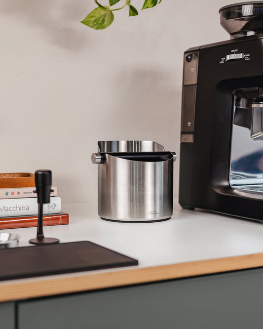 14 cm zilveren uitklopbak op het werkblad naast een koffiemachine