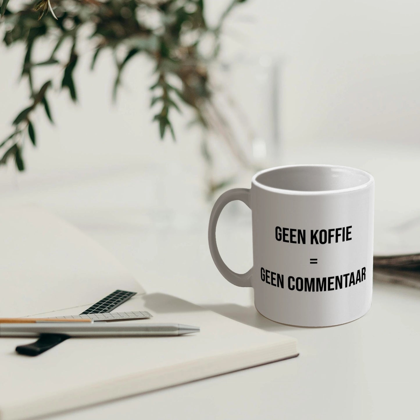 Koffiemok met dubbelzijdige tekst βGeen koffie = geen commentaarβ, zichtbaar voor iedereen.