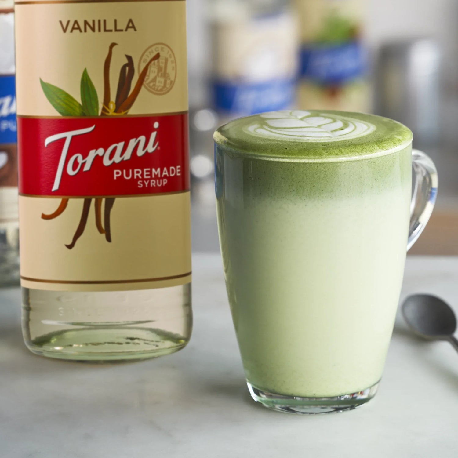 Torani vanille puremade siroop naast een matcha latte met vanille als smaakmaker