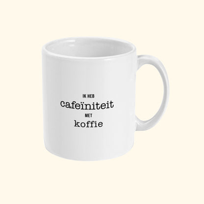 Koffie mok met leuke tekst Ik Heb Cafeïniteit Met koffie. Zijaanzicht.