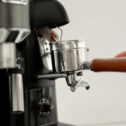 Zilveren doseerring op portafilter tijdens espresso malen voor minder gemorste koffie rond de espressomachine