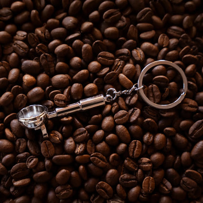 Barista filterdrager sleutelhanger ligt op gebrande specialty coffee koffiebonen