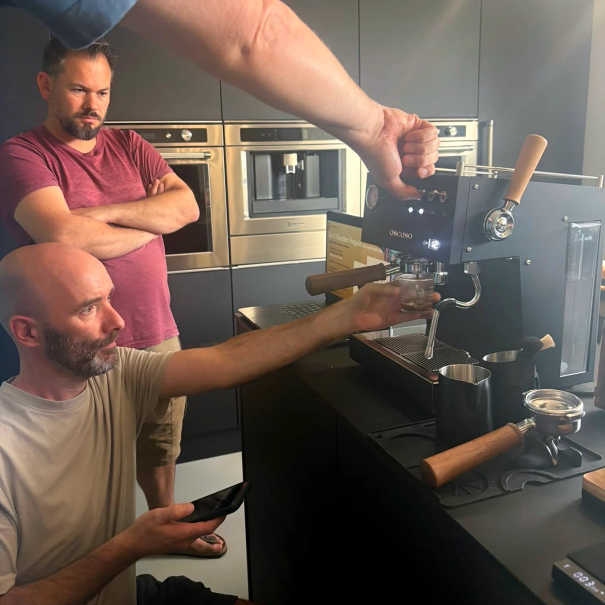 Geert-Jan de Baristaman timet een espresso-extractie op een Ascaso-espressomachine tijdens een barista workshop aan huis op de eigen espressomachine, in het bijzijn van deelnemers.