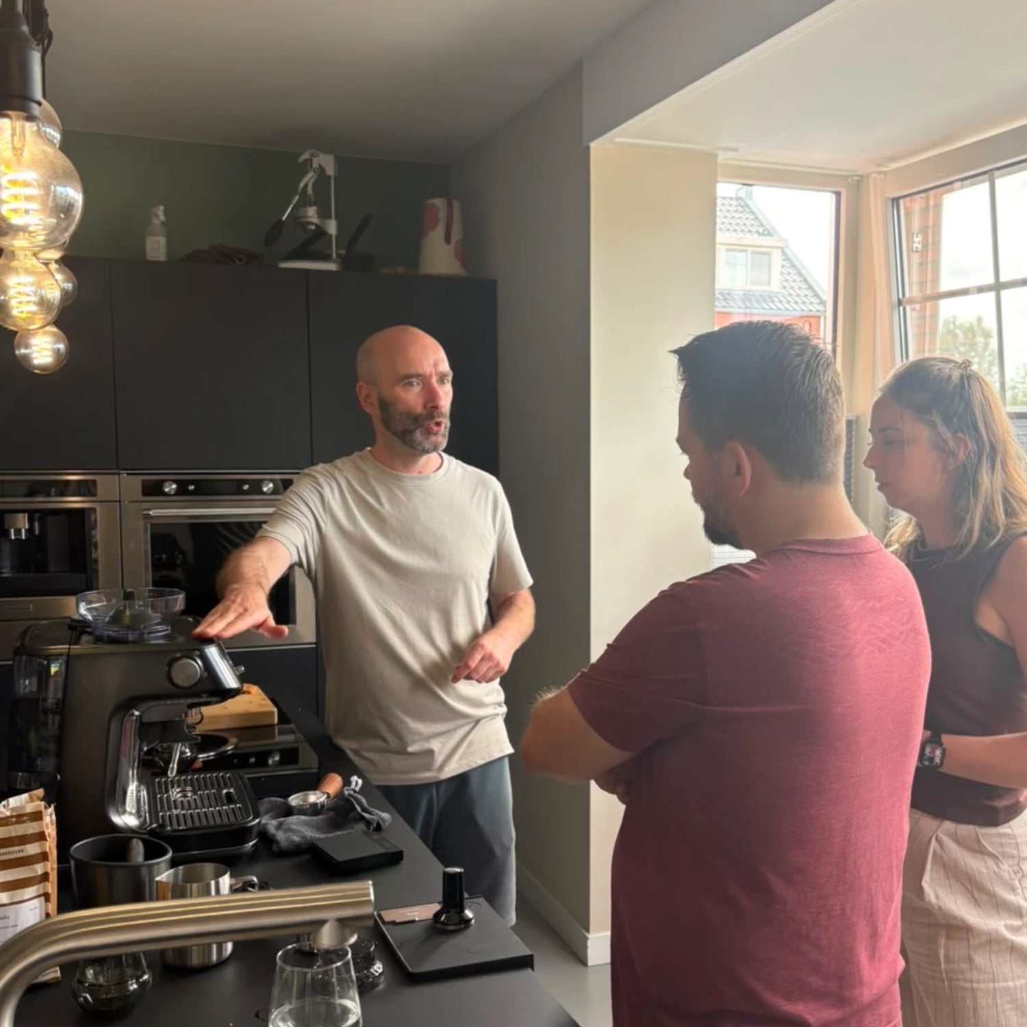 Geert-Jan de Baristaman geeft twee deelnemers uitleg over het gebruik van hun Sage Barista Pro tijdens een barista workshop aan huis op de eigen espressomachine.