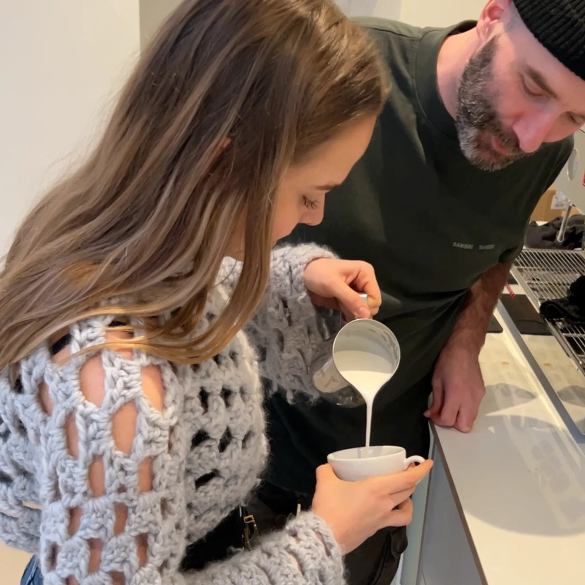 Een deelnemer schenkt een perfect hartje in zijn cappuccino tijdens de Barista Workshop in Amsterdam.