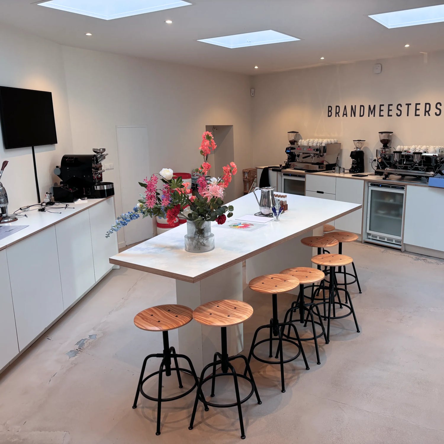 Overzicht van de barista workshop trainingsruimte in Amsterdam met espressomachines, werkblad en zitplaatsen.