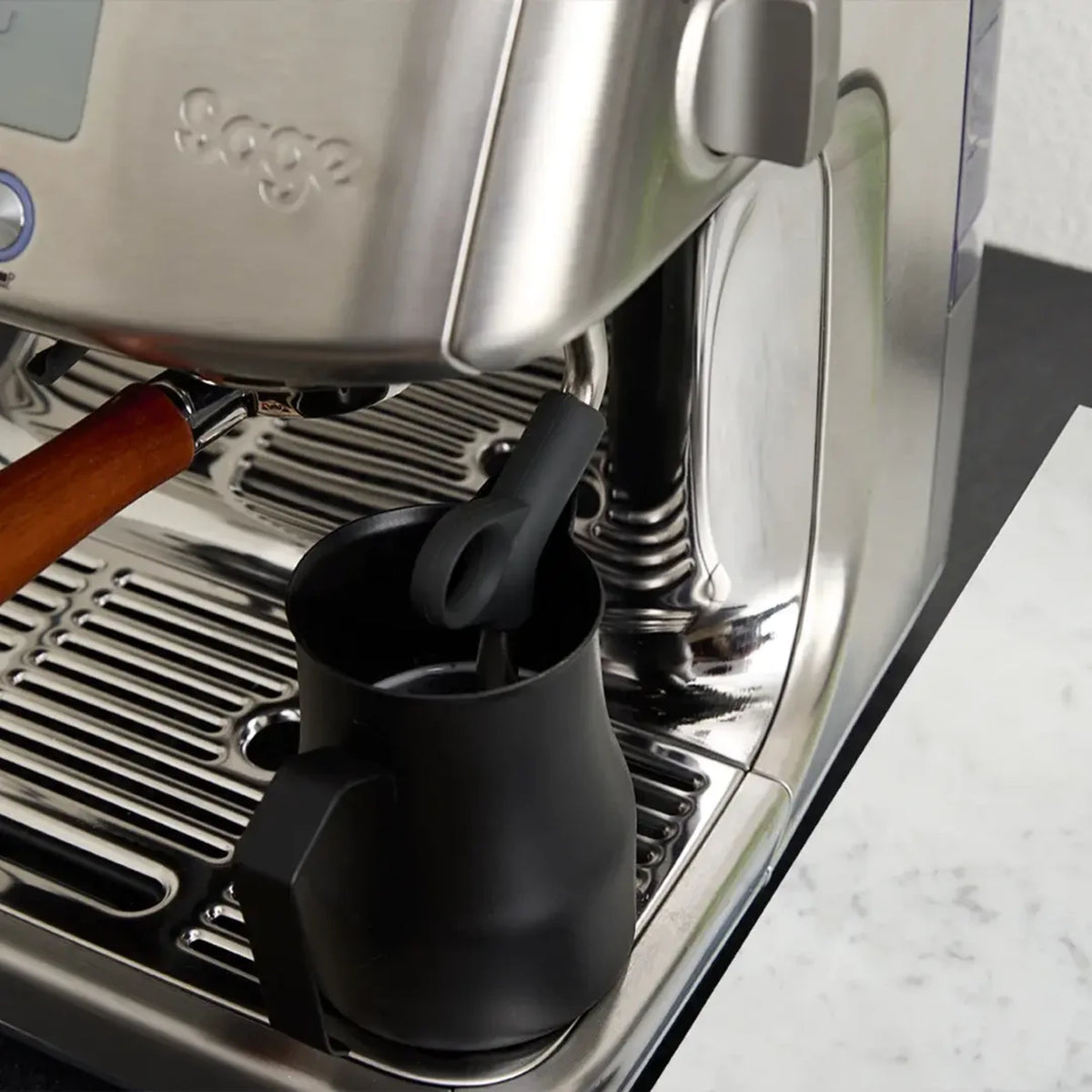 Stoompijp van een espressomachine in een zwarte kan