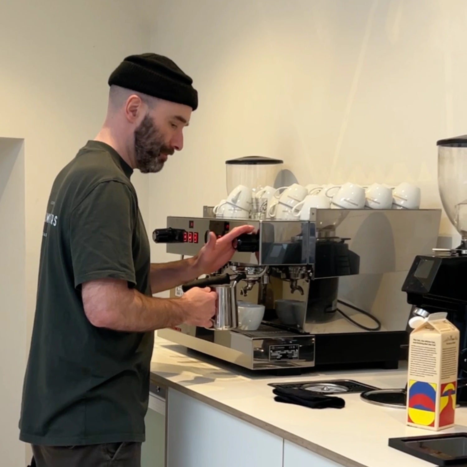 Barista-coach werkt met de espressomachine in de trainingsruimte tijdens een workshop.