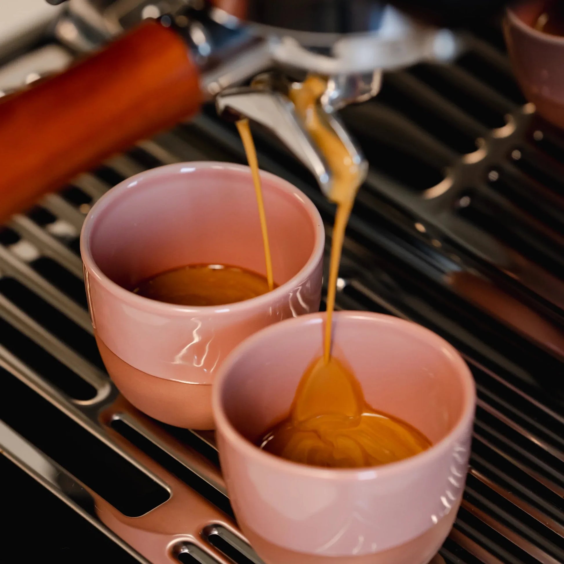 Dubbele espresso van Cuba bonen met rijke cremalaag gezet op een Sage espressomachine in roze kopjes.