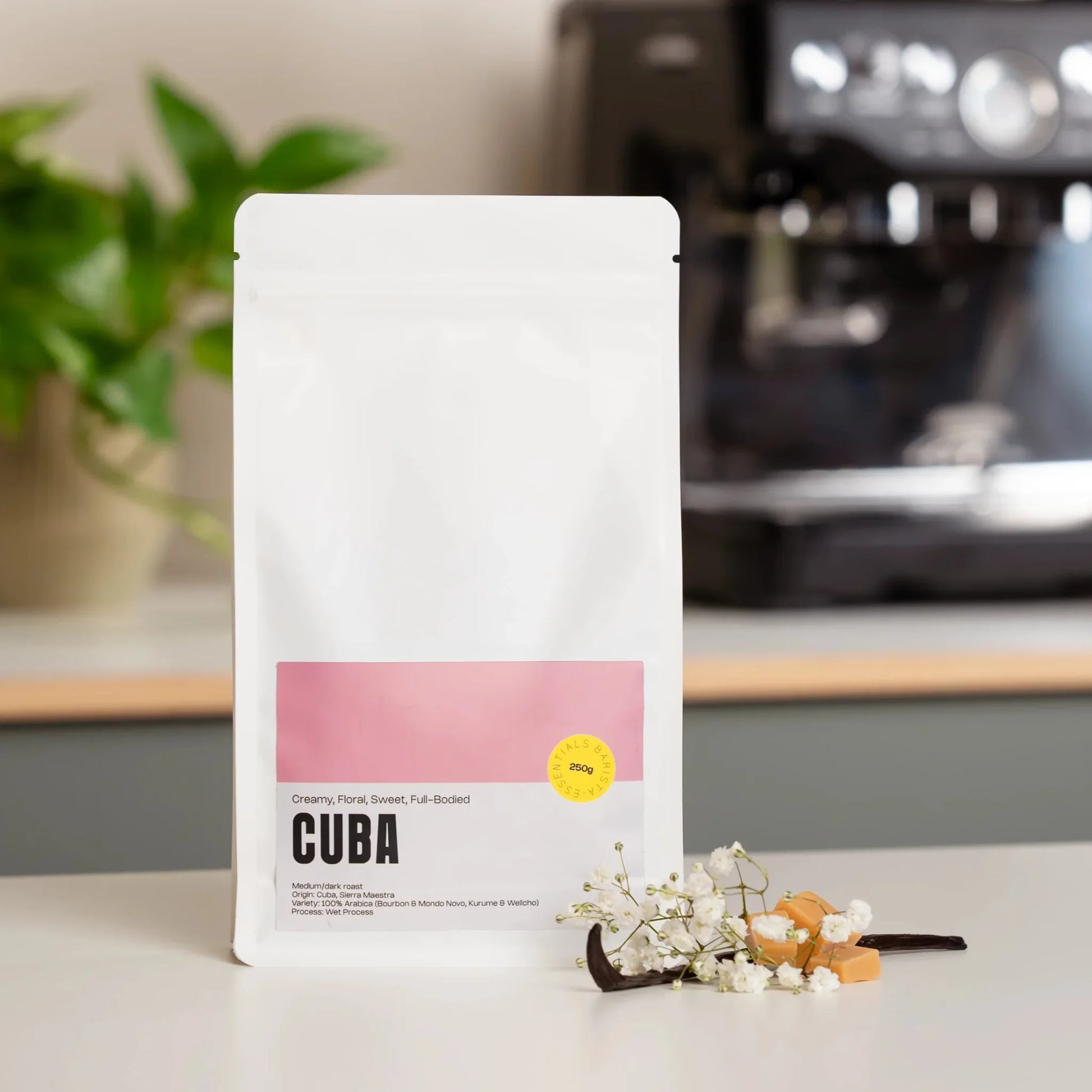 Zak Cuba specialty coffee met romige en bloemige smaaktonen naast een Sage espressomachine op het aanrecht.