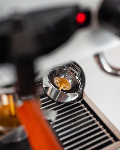 Onderaanzicht van espresso die door een convex filterbakje van 58 mm stroomt