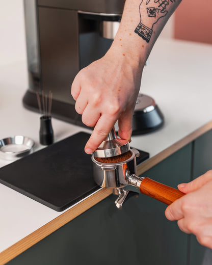 Hand op de rvs tamper tijdens het tampen