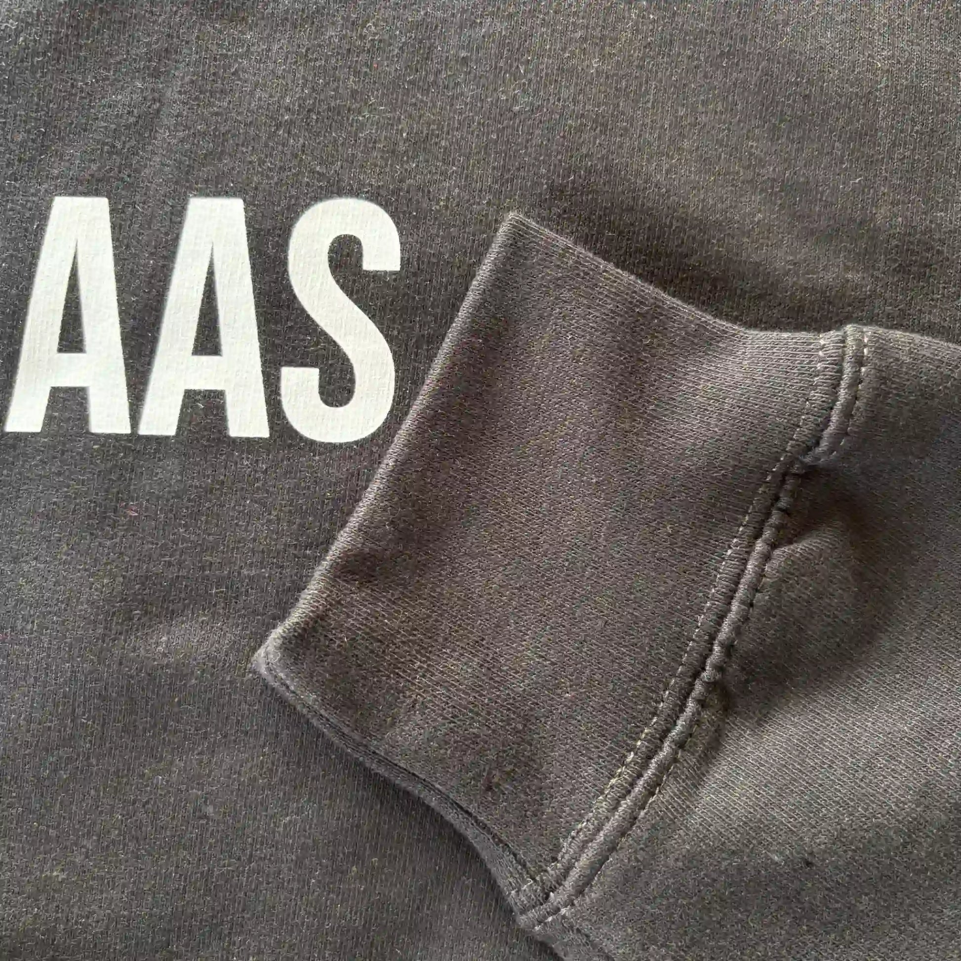 Detail van mouw en opdruk van het zwarte “KOFFIEBAAS” sweatshirt voor koffieliefhebbers