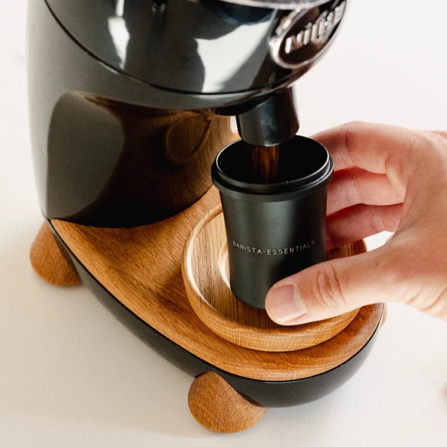 Zwarte Doseerbeker V2 51mm onder een koffiemolen voor het netjes opvangen van gemalen koffie