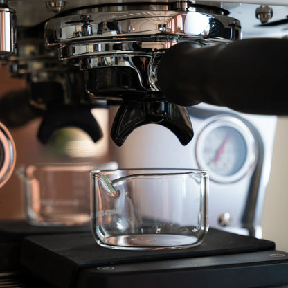 Espresso shotglas 60 ml onder portafilter op koffieweegschaal voor nauwkeurige extractiecontrole