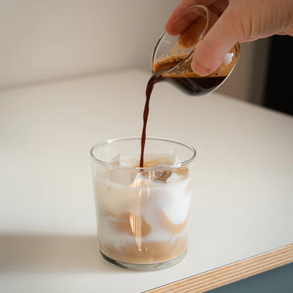 Espresso shotglas met schenktuit waarmee verse espresso wordt overgegoten in iced coffee
