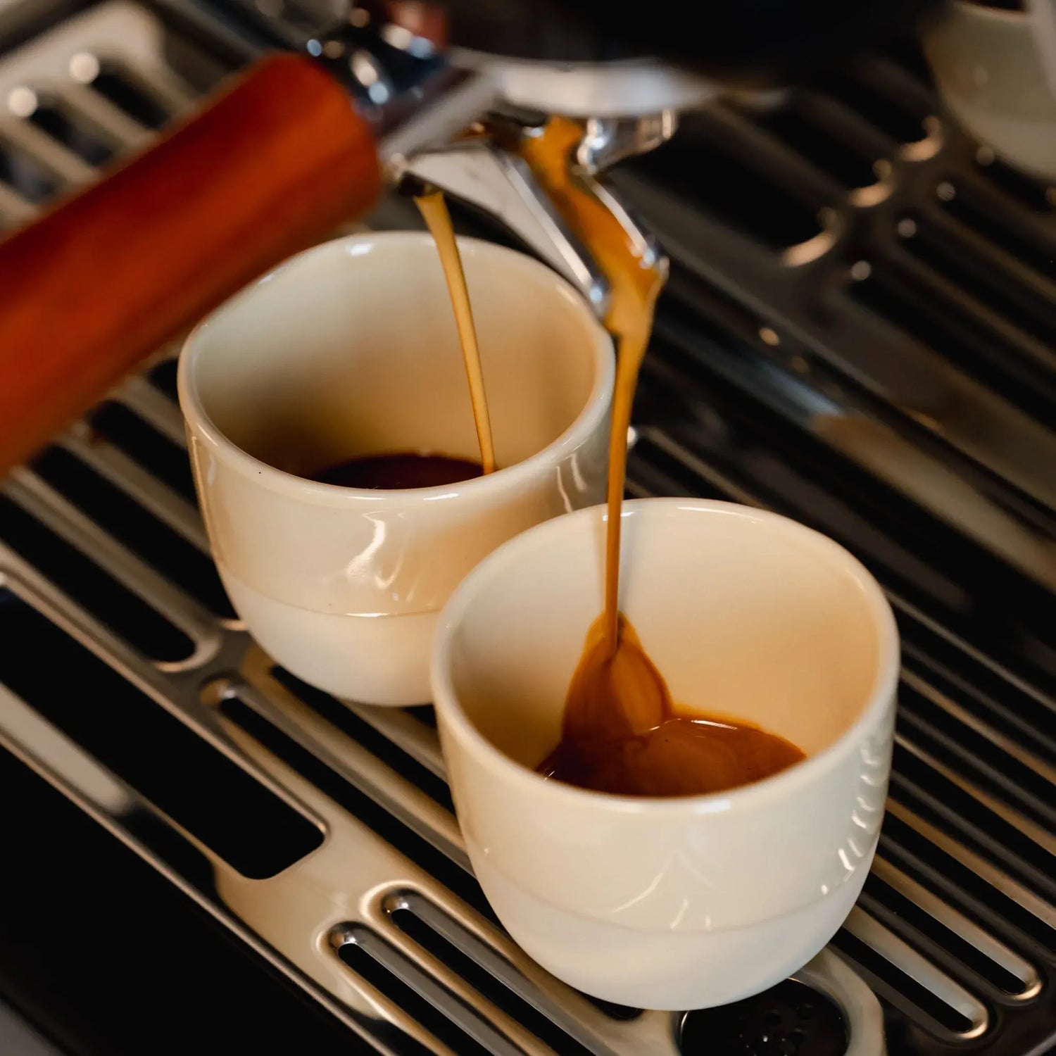 Twee zandgele espressokopjes (60 ml) onder een espressomachine met stoompijpje van De’Longhi of Sage. Perfect formaat voor een dubbele espresso, handgemaakt porselein dat je cremalaag beschermt en snel opwarmt. Voor echte thuisbarista's.