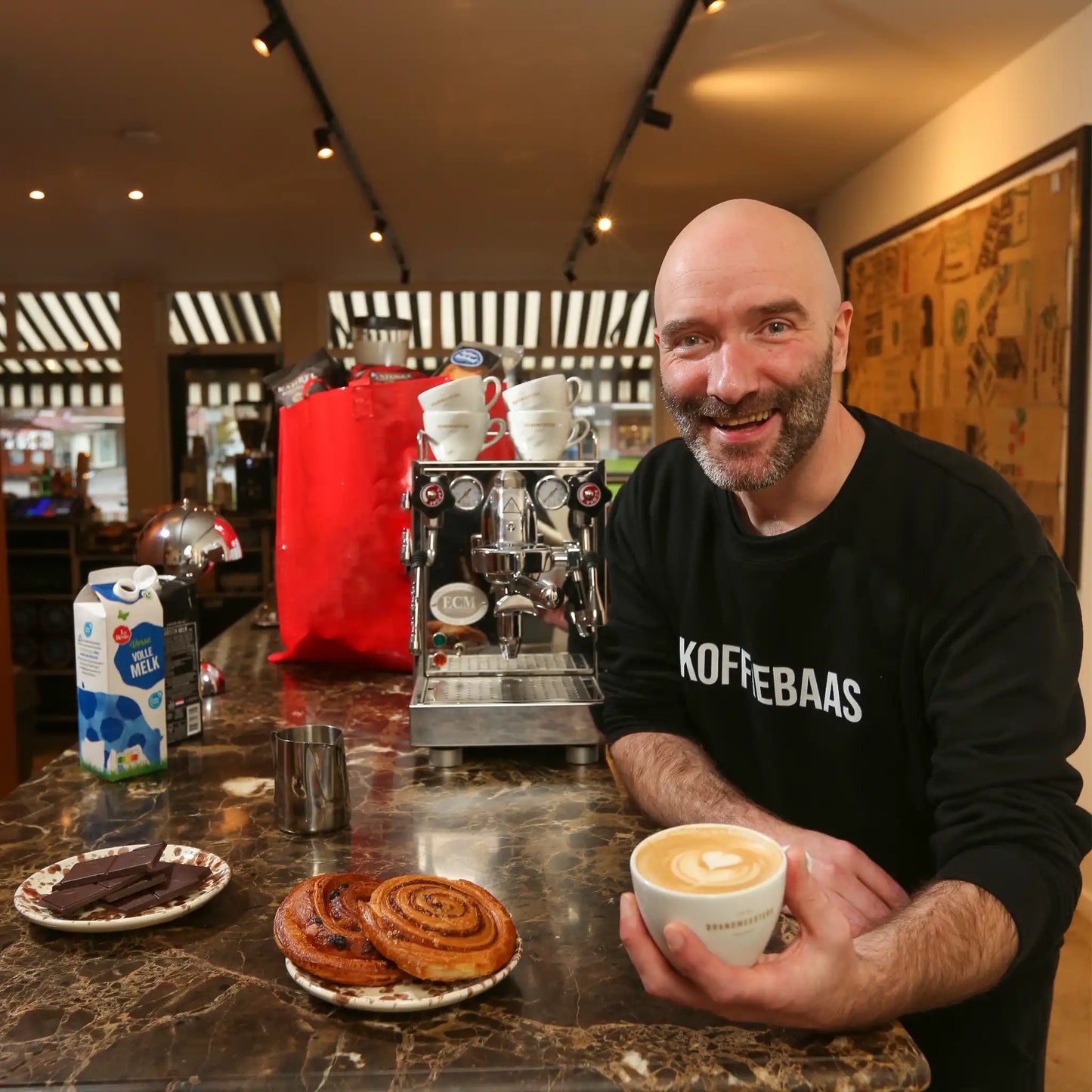 Geert-Jan van der Molen geeft privé barista coaching aan huis en serveert een latte tijdens een persoonlijke espresso workshop met professionele espressomachine.