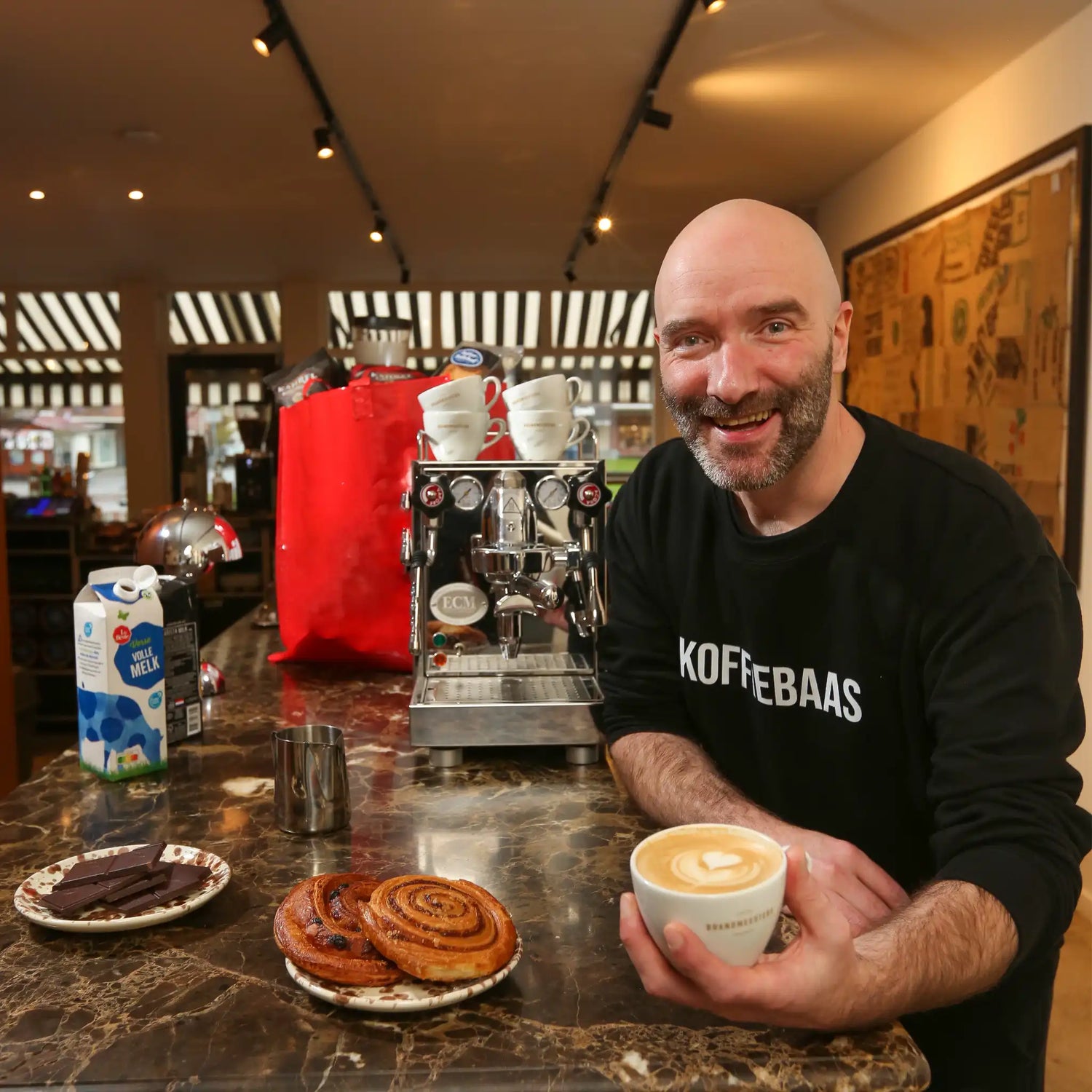 Geert-Jan van der Molen geeft privé barista coaching aan huis en serveert een latte tijdens een persoonlijke espresso workshop met professionele espressomachine.