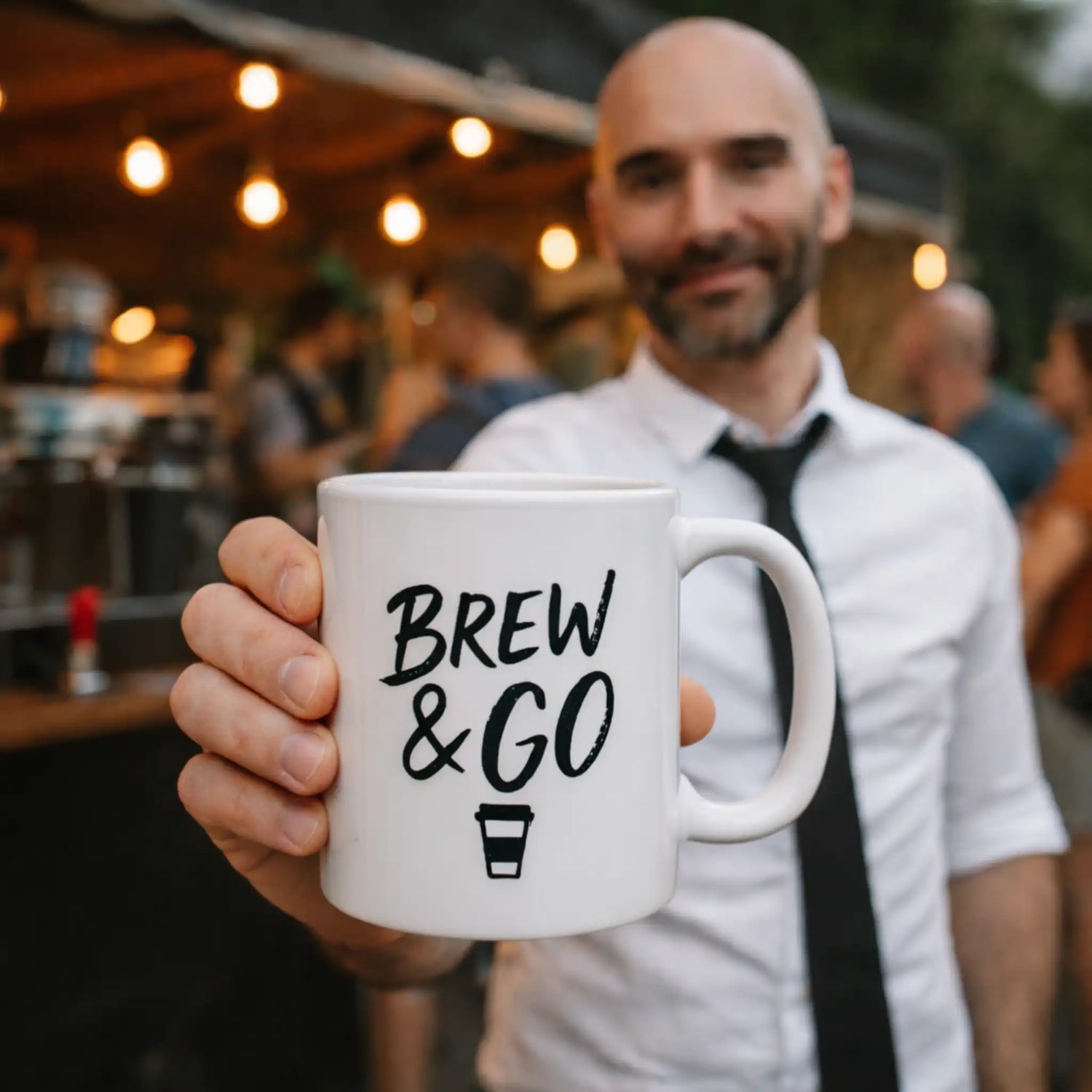 Gepersonaliseerde bedrukte koffiemok voor bedrijven met eigen logo, gepresenteerd door ondernemer voor foodtruck met wachtende klanten op de achtergrond.