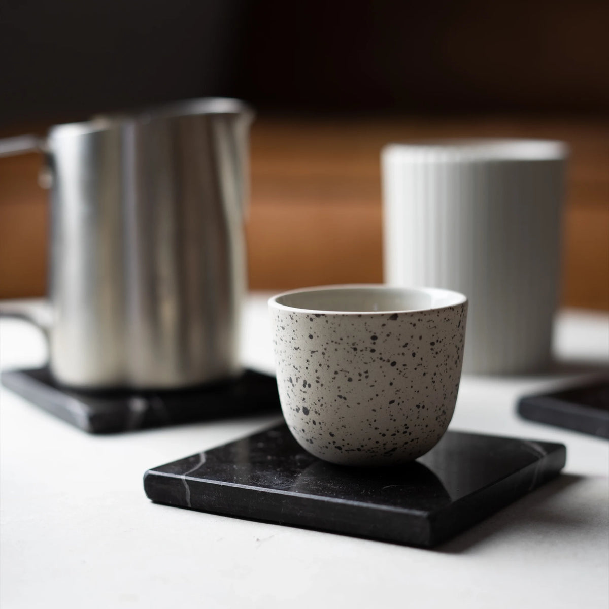 Gestippeld kopje op een weegschaal onder een espressomachine