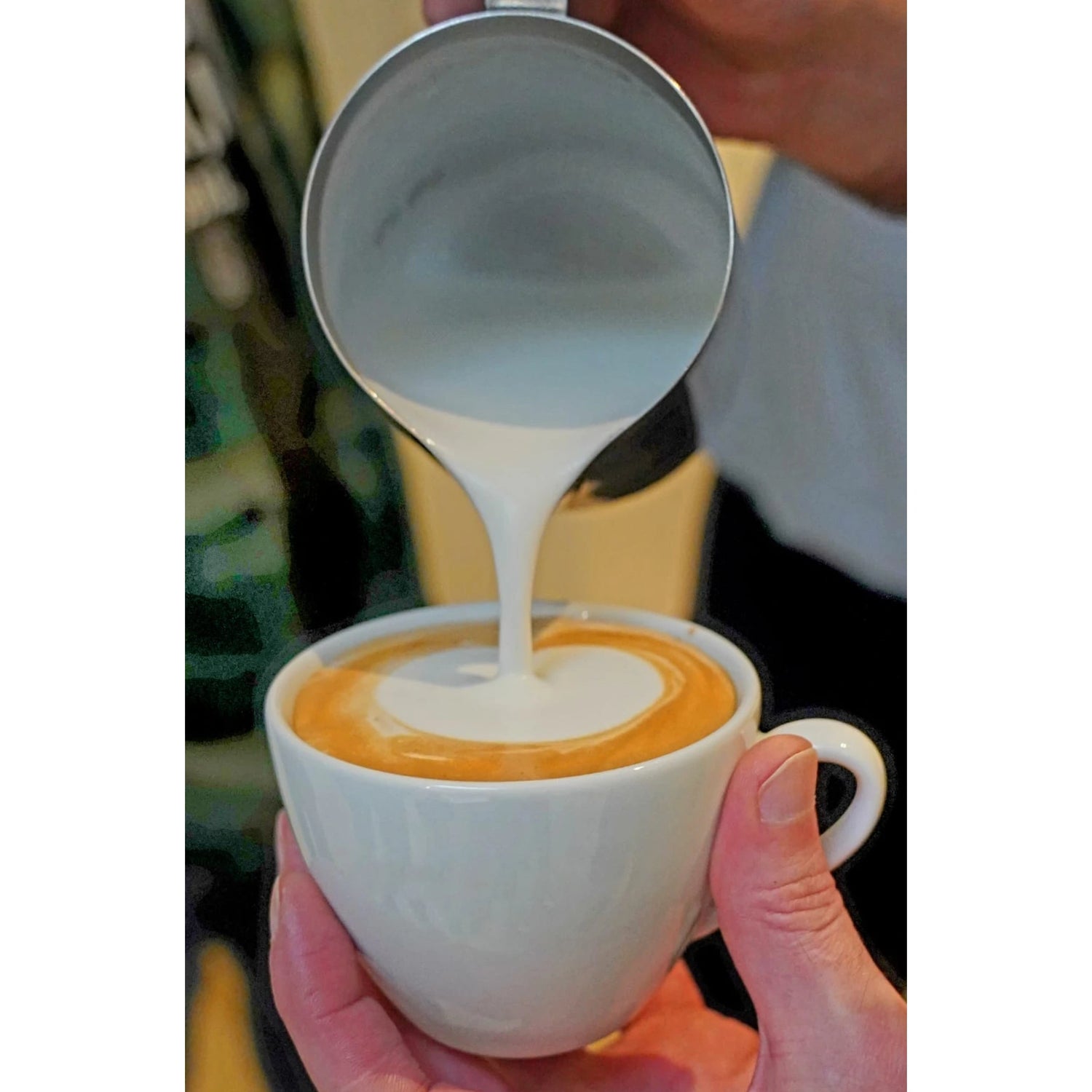 Close-up van een perfect hartje geschonken in een cappuccino tijdens de workshop.