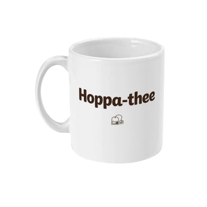 Minimalistische witte thee mok met de tekst Hoppa-thee en klein thee-icoon, ideaal als cadeau voor thee-liefhebbers.