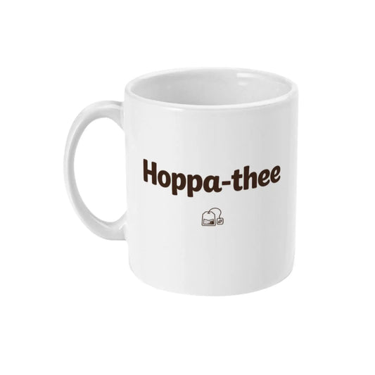 Minimalistische witte thee mok met de tekst Hoppa-thee en klein thee-icoon, ideaal als cadeau voor thee-liefhebbers.