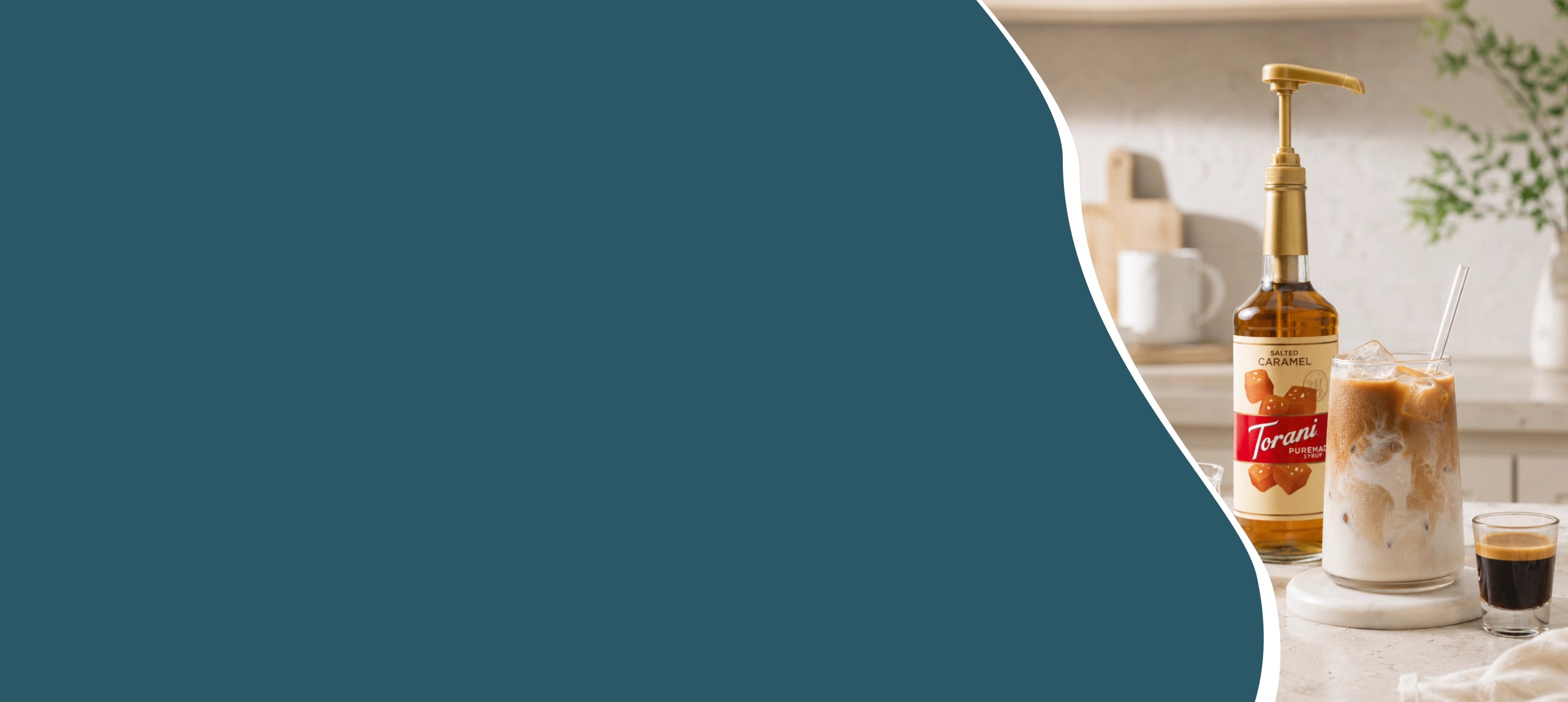 Hero banner met een glas iced coffee met espresso, melk, ijsblokjes en Torani koffiesiroop op een thuisbarista koffiestation