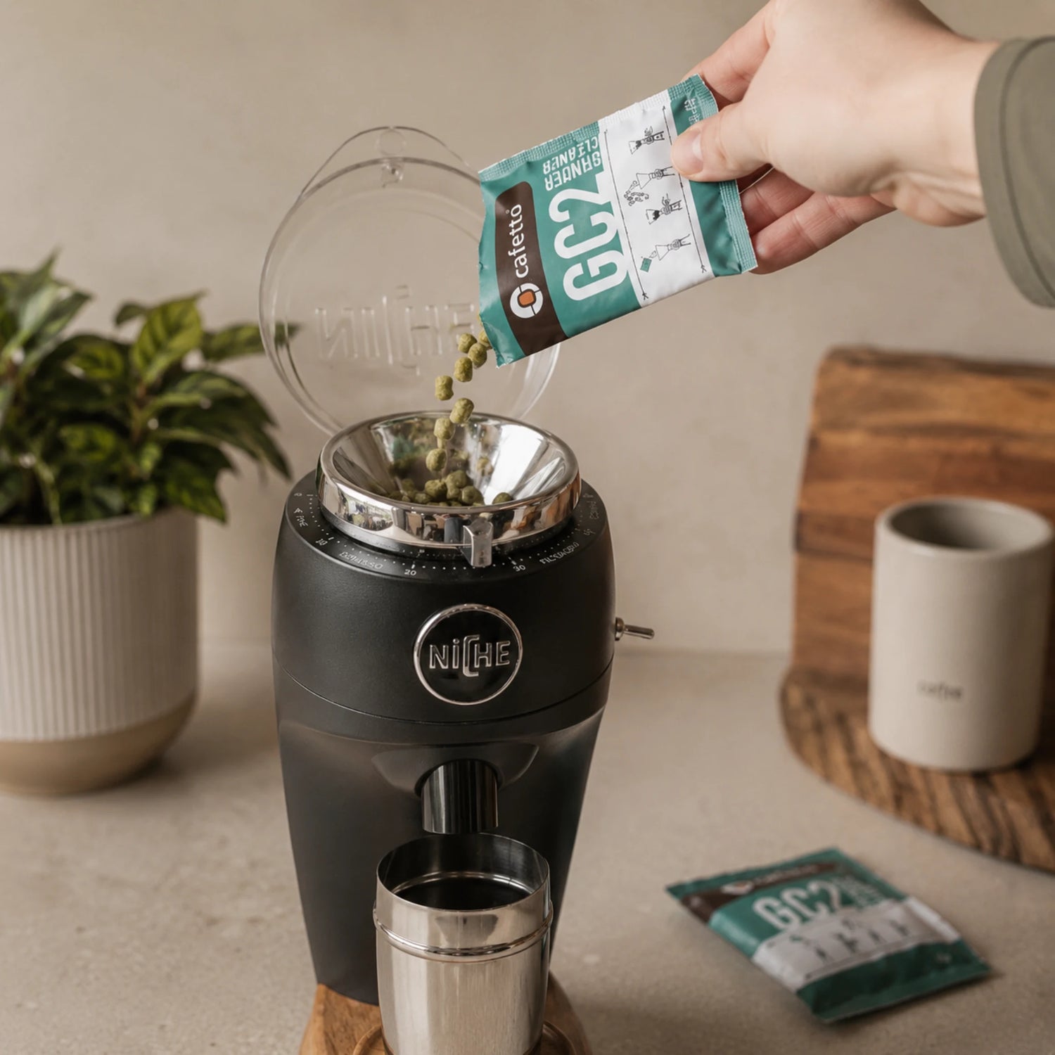 Koffiemolen reinigen met reinigingskorrels naast koffiebonen en portafilter voor beter koffiemolen onderhoud thuis