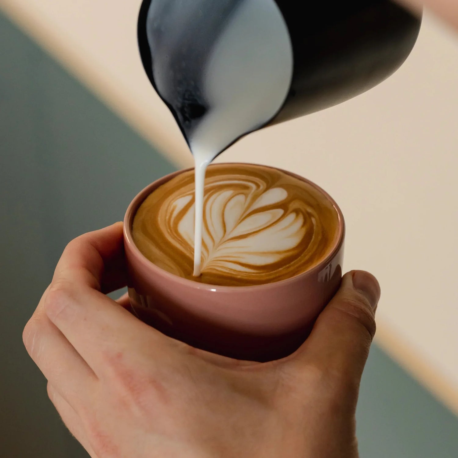 Latte art wordt gegoten in een 250 ml latte kopje van terracotta pink porselein. Ideaal voor thuisgebruik met De’Longhi, Gaggia of Krups espressomachines met stoompijpje. Handgemaakt, stapelbaar en perfect voor microfoam.