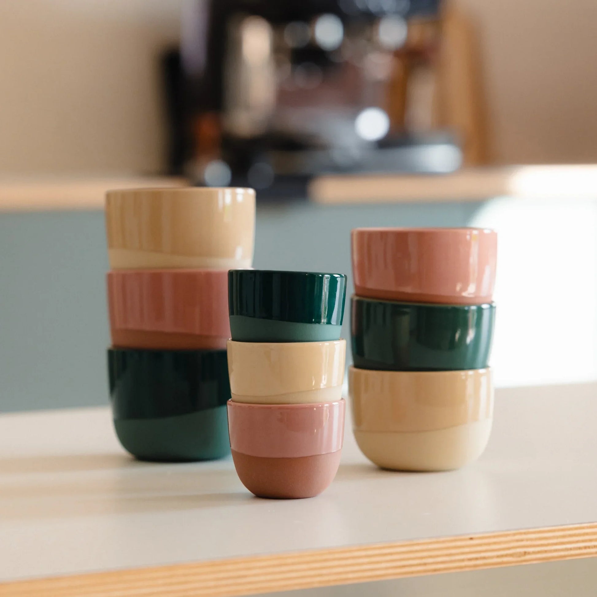 Stapelbare porseleinen latte kopjes in terracotta pink (250 ml) op tafel. Ambachtelijk vervaardigd, ideaal voor barista’s thuis met Krups of Gaggia machine. Geschikt voor latte art, vaatwasserbestendig en kleurvast.