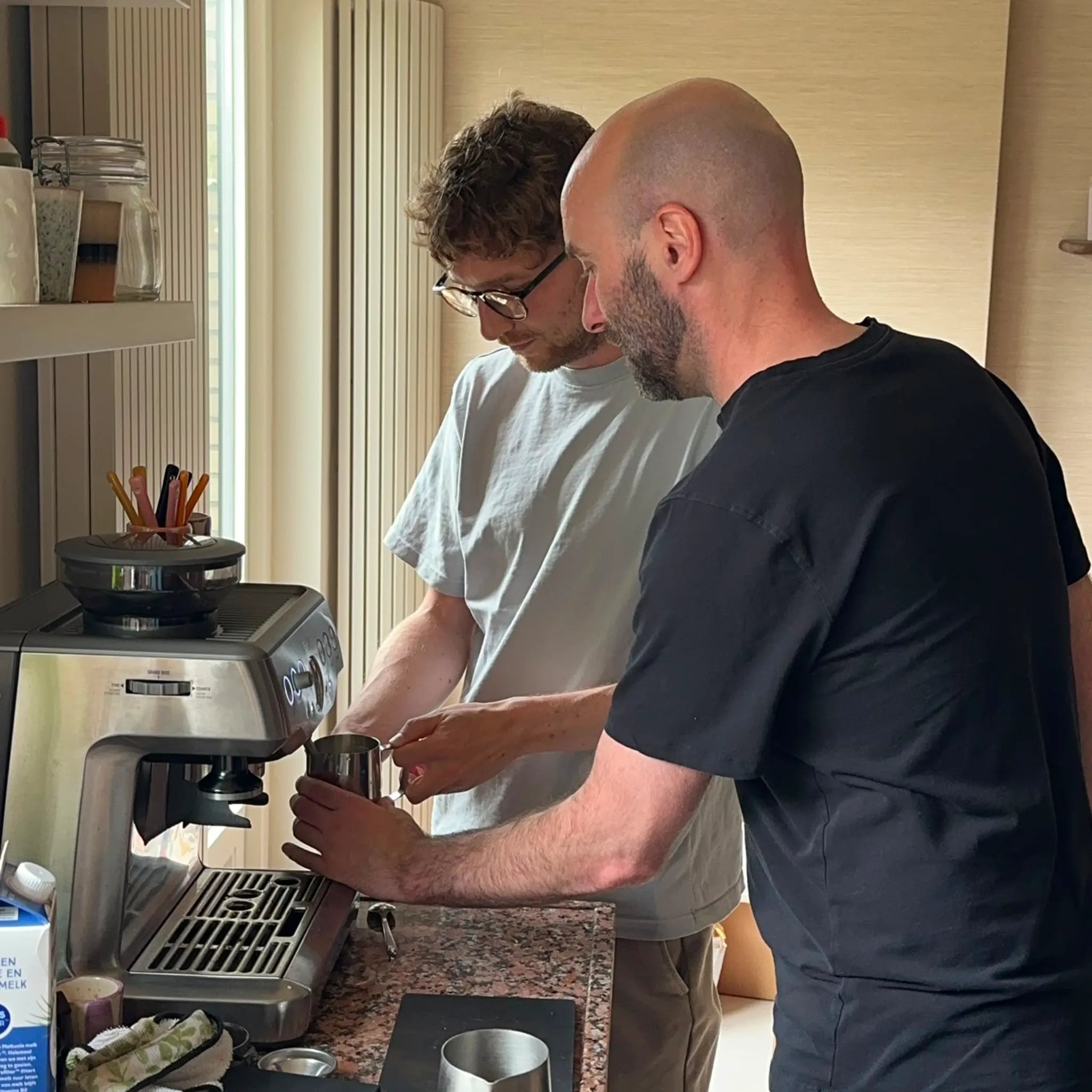Geert-Jan de Baristaman helpt een thuisbarista met melkschuimen op de eigen espressomachine tijdens een privé training aan huis.