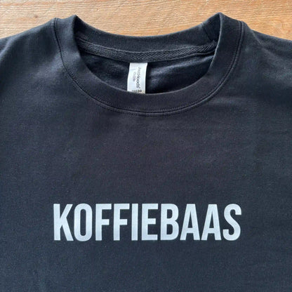 Zwarte KOFFIEBAAS sweater platgelegd met zichtbare witte print