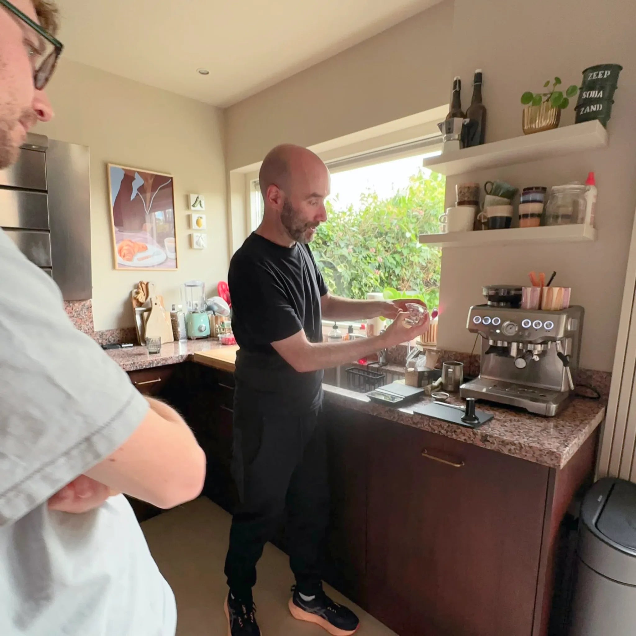 Geert-Jan de Baristaman legt tijdens een privé barista training thuis uit hoe je koffie zet met de eigen espressomachine.