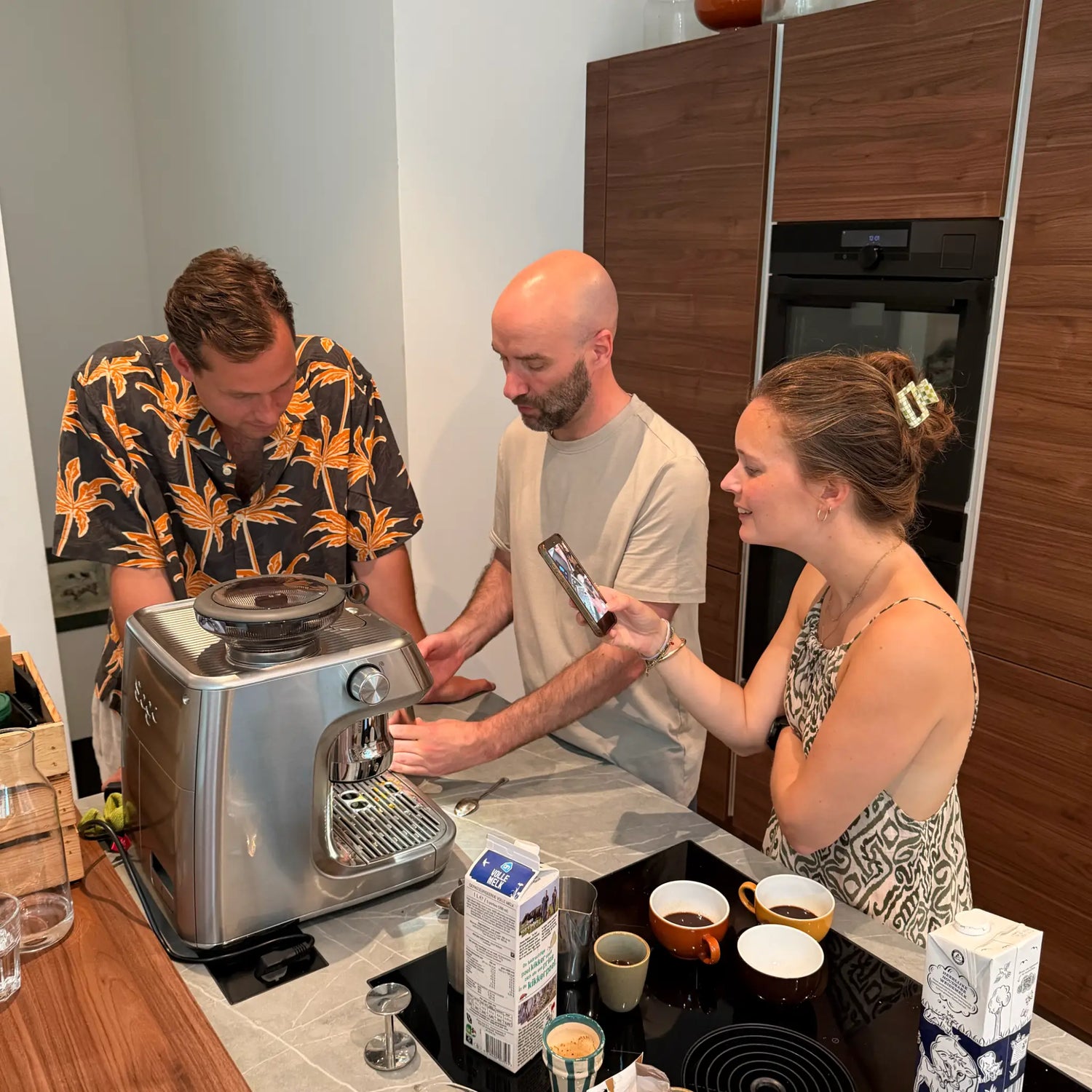 Deelnemers oefenen samen met hun eigen espressomachine tijdens een privé barista workshop in de keuken thuis.