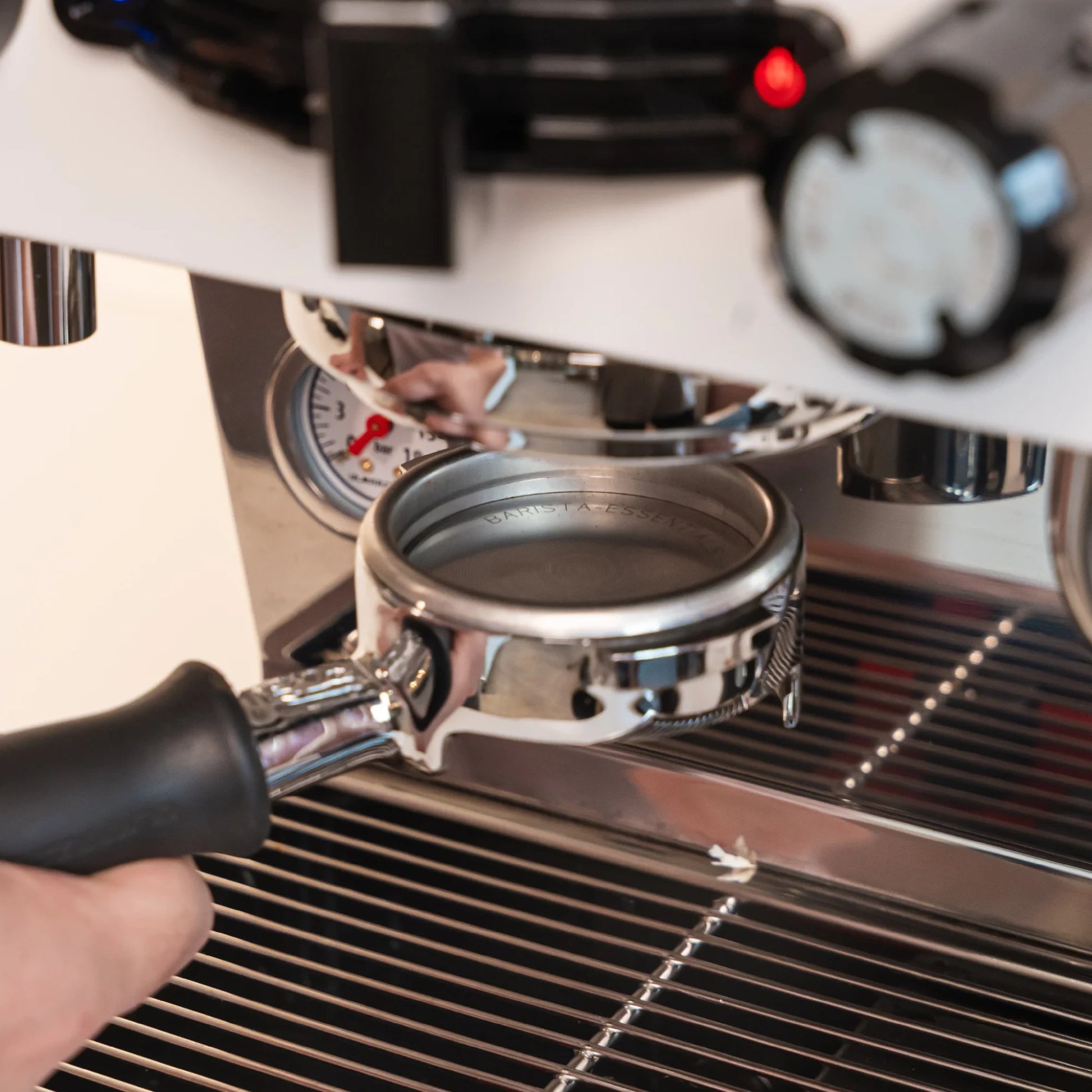58,5 mm puck screen in een portafilter onder de zetgroep van een E61-espressomachine.
