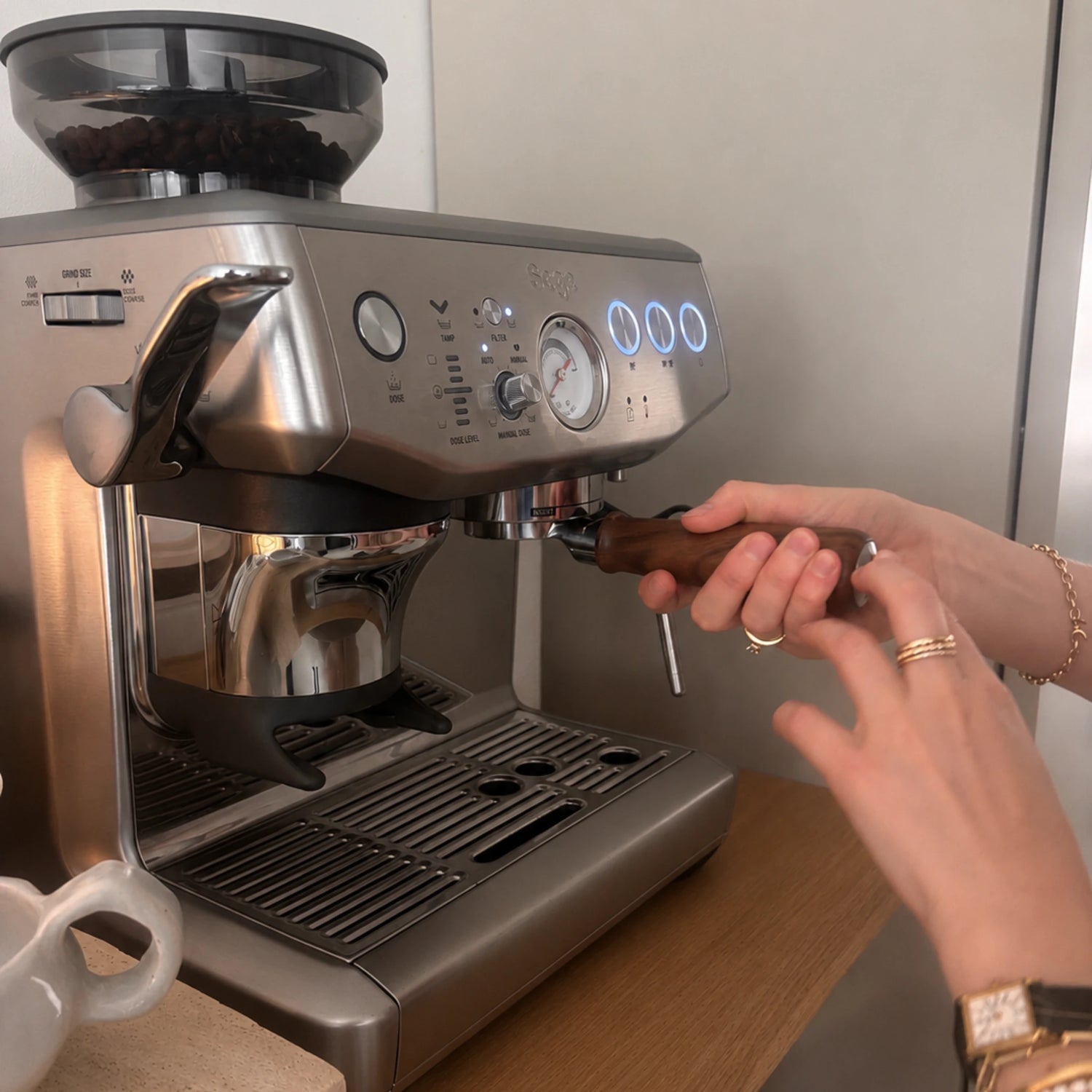 Deelnemer plaatst de portafilter in een Sage Barista Express Impress tijdens een privé barista workshop aan huis op de eigen espressomachine.