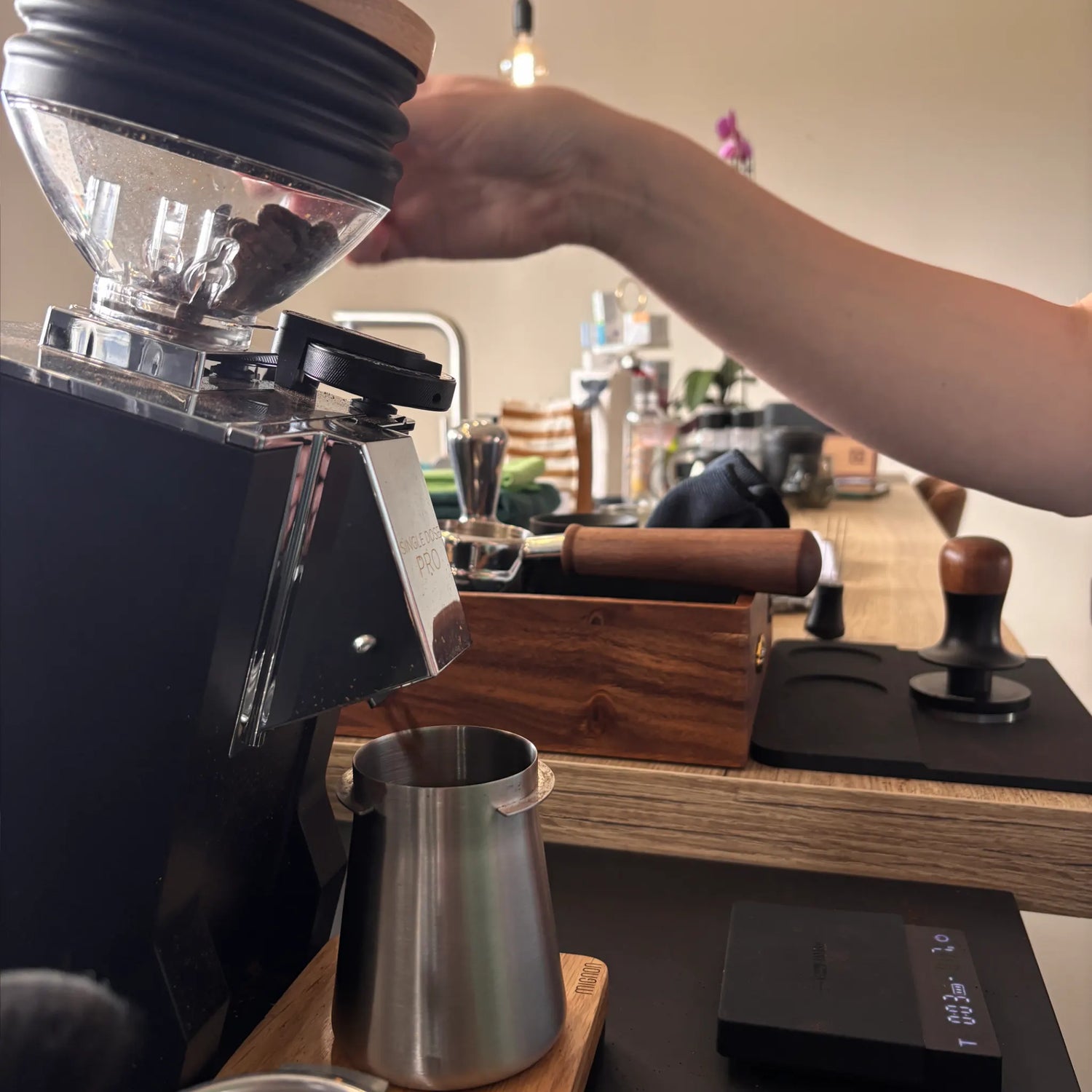 Koffiebonen worden gemalen met een single-dose koffiemolen tijdens een privé barista workshop aan huis.