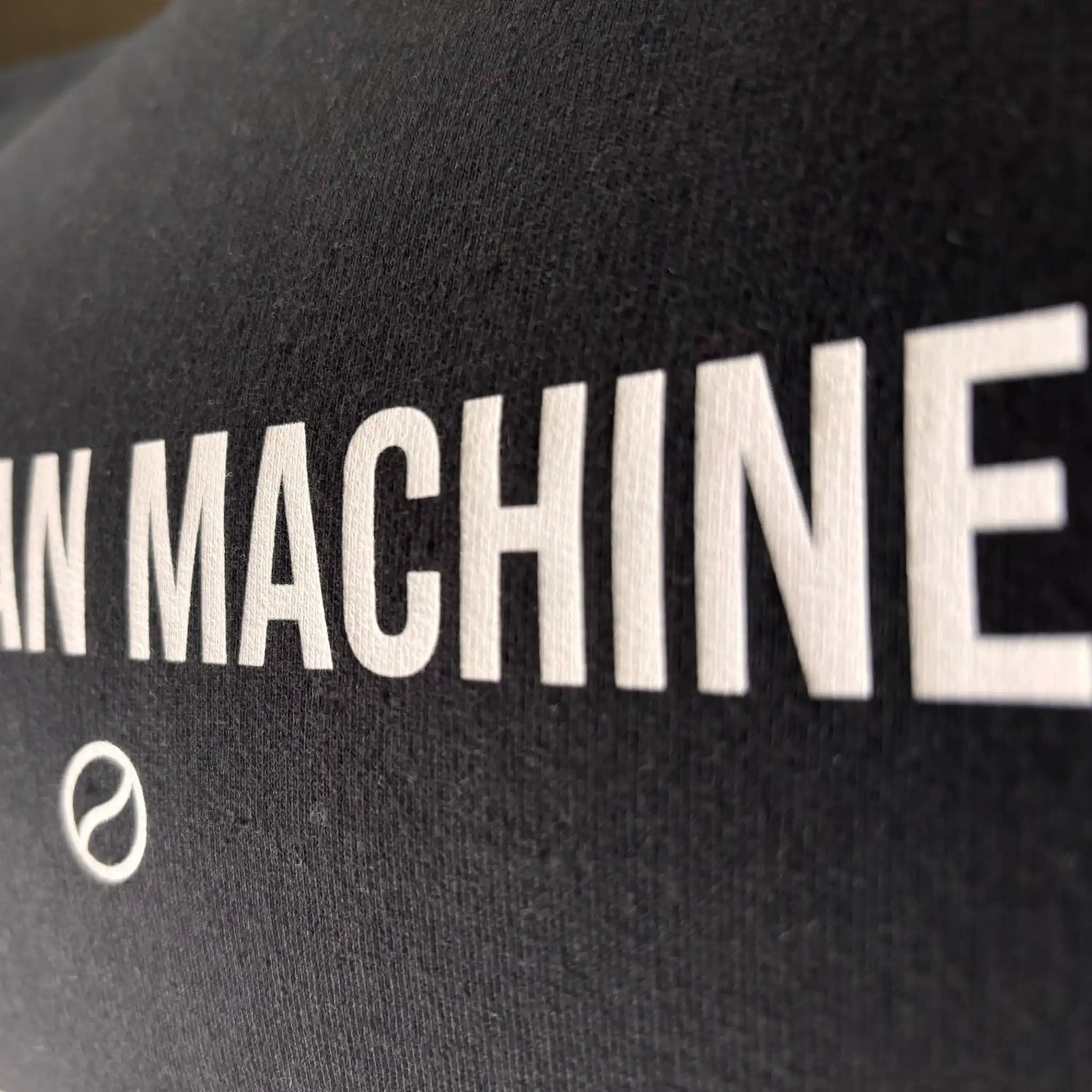 Gedetailleerd beeld van de print op The Bean Machine sweatshirt; hoogwaardige opdruk op deep black katoenmix – een echte must-have voor barista's.