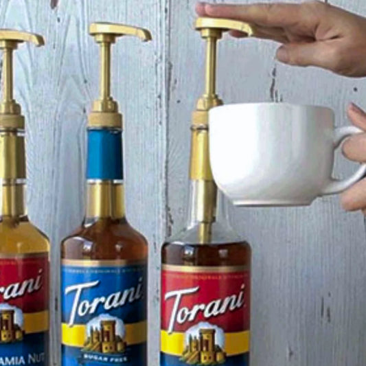 Gouden Torani sirooppomp bevestigd op een fles Caramel Siroop.
