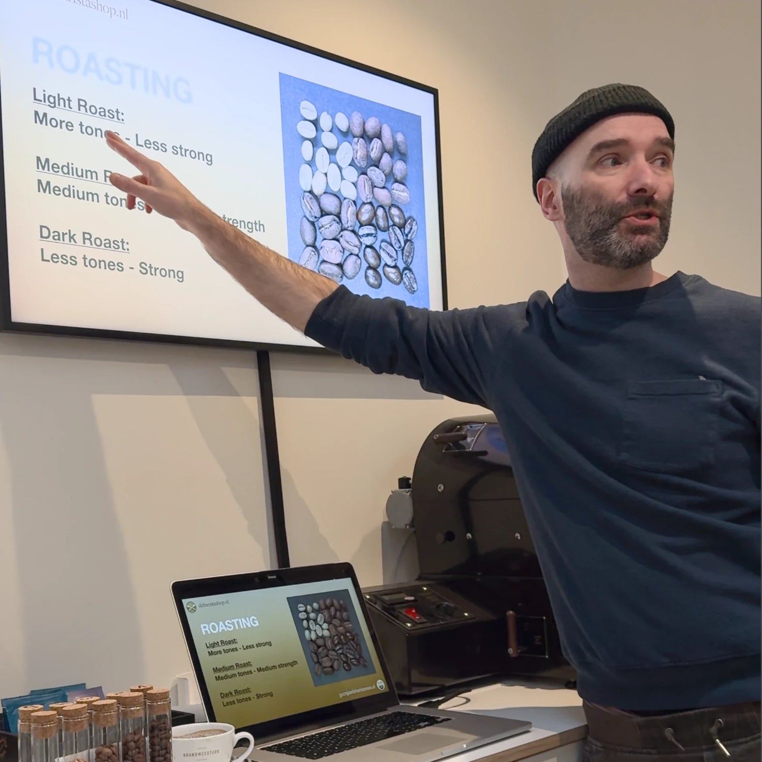 Trainer geeft een digitale presentatie over koffiebonen en branding tijdens de workshop.