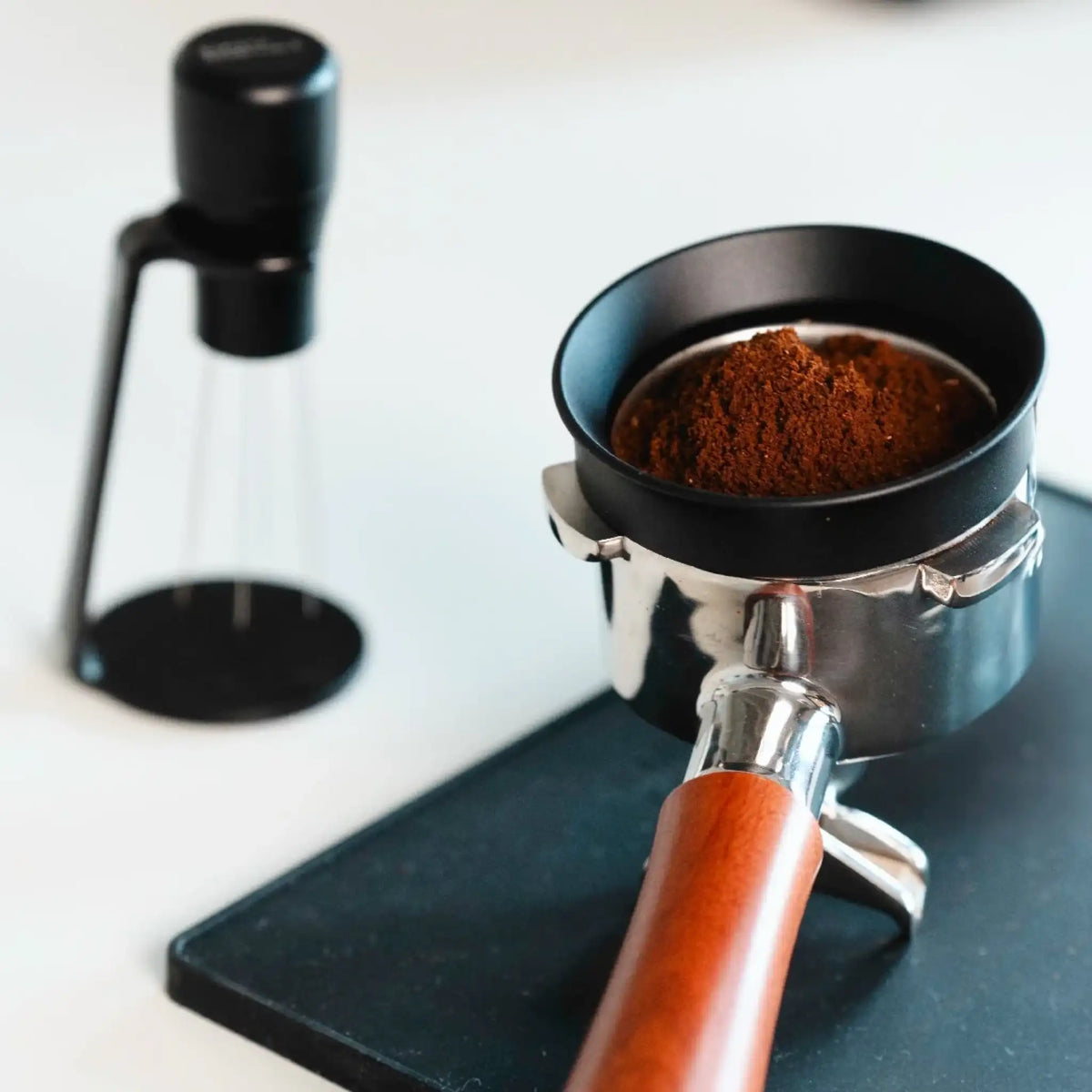 Portafilter met doseerring en gemalen koffie klaar voor gebruik met een WDT-tool vóór het tampen