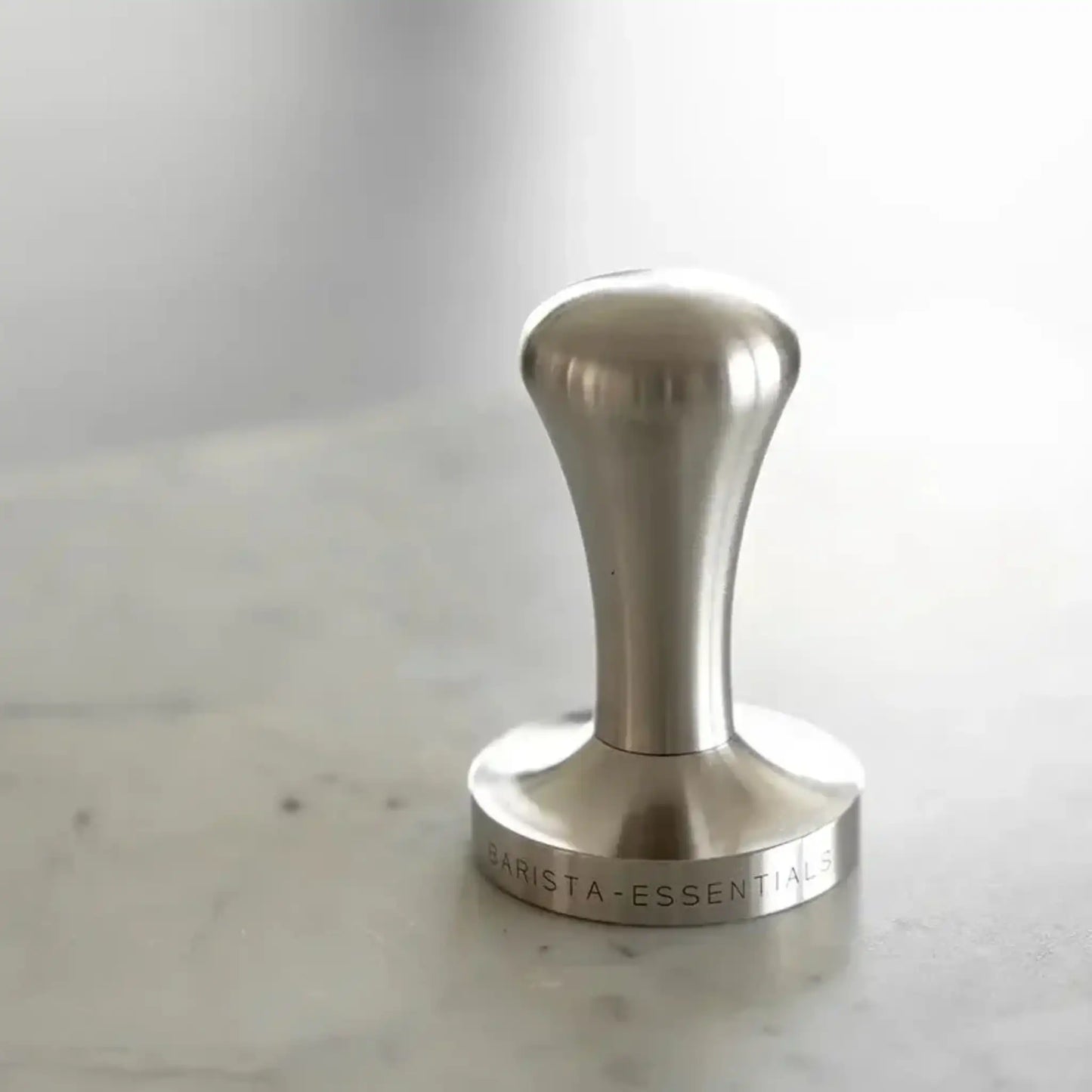 Zware RVS espresso tamper 58mm van Barista-Essentials op marmeren werkblad